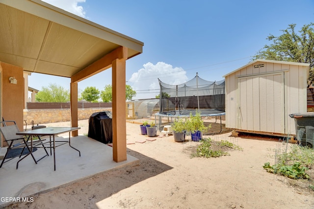 13261 Walker Post Ave, El Paso, TX 79928 - fenced backyard with a trampoline, a shed, a patio area, outdoor dining space, and a grill