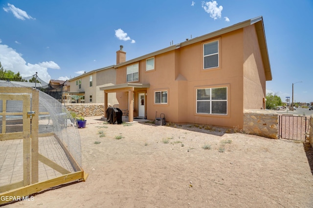 13261 Walker Post Ave, El Paso, TX 79928 - back of property with a chimney, stucco siding, and a gate