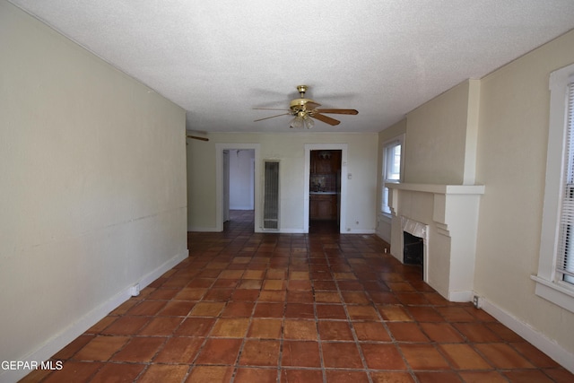1275 Prospect St, El Paso, TX 79902 - unfurnished living room with ceiling fan, a fireplace, a textured ceiling, baseboards, and tile patterned floors