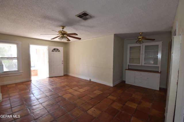 1275 Prospect St, El Paso, TX 79902 - unfurnished room with a ceiling fan, baseboards, a heating unit, a textured ceiling, and dark tile patterned floors