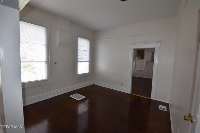 1275 Prospect St, El Paso, TX 79902 - empty room featuring dark wood-style floors, baseboards, and healthy amount of natural light