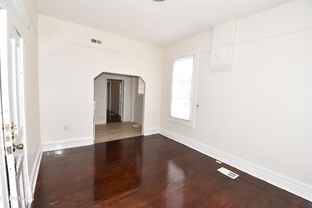 1275 Prospect St, El Paso, TX 79902 - empty room with arched walkways, dark wood-style flooring, and baseboards
