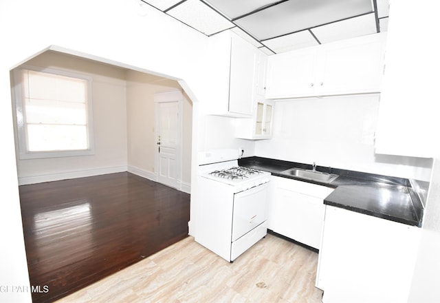 1275 Prospect St, El Paso, TX 79902 - kitchen featuring white gas range, a sink, white cabinetry, and light wood-style flooring