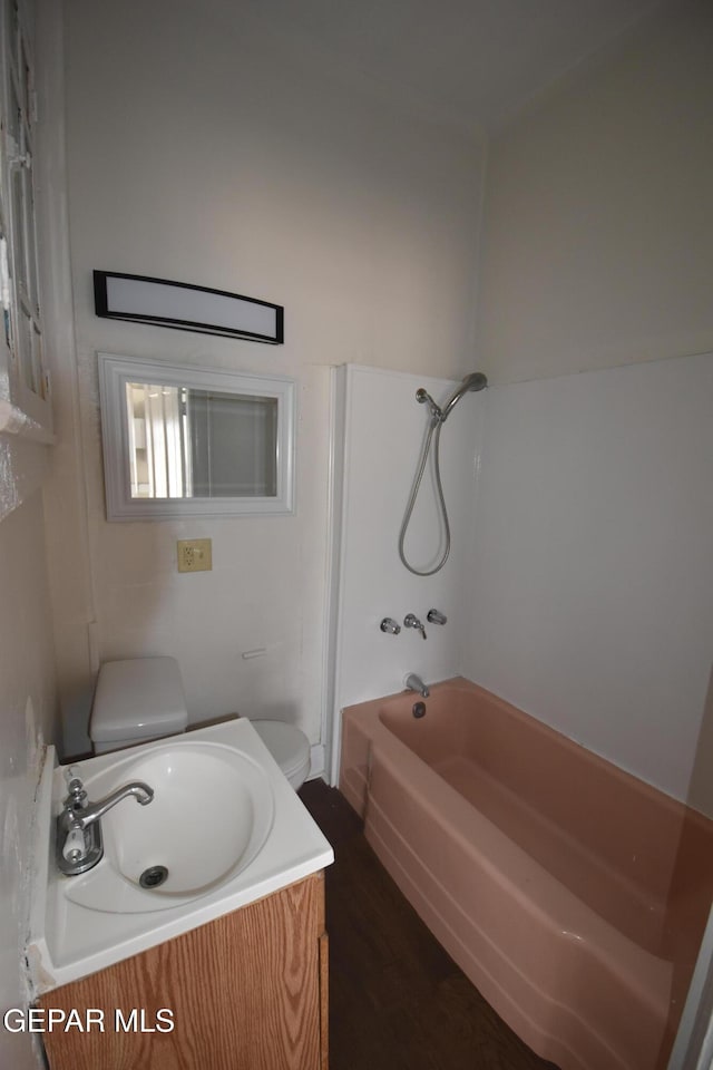 1275 Prospect St, El Paso, TX 79902 - bathroom featuring toilet, vanity, wood finished floors, and shower / washtub combination