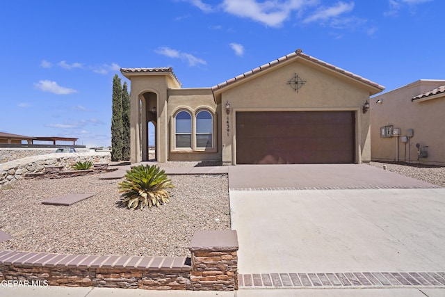 14391 Loma Esmeralda, El Paso, TX 79938 - mediterranean / spanish-style home with a garage, driveway, stucco siding, and a tile roof