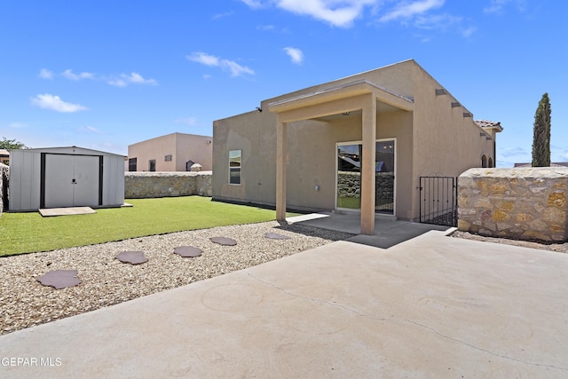 14391 Loma Esmeralda, El Paso, TX 79938 - rear view of house featuring a storage unit, a patio area, stucco siding, and a gate