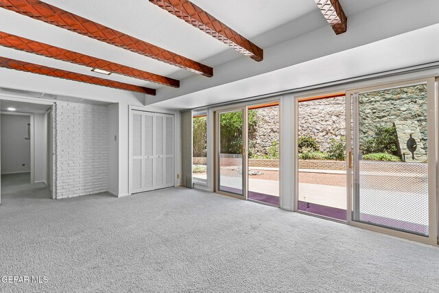 408 Spring Hill Cir, El Paso, TX 79912 - unfurnished bedroom with access to outside, beam ceiling, carpet, and brick wall