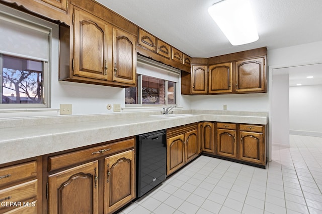 408 Spring Hill Cir, El Paso, TX 79912 - kitchen with dishwasher, light tile patterned floors, light countertops, and brown cabinetry