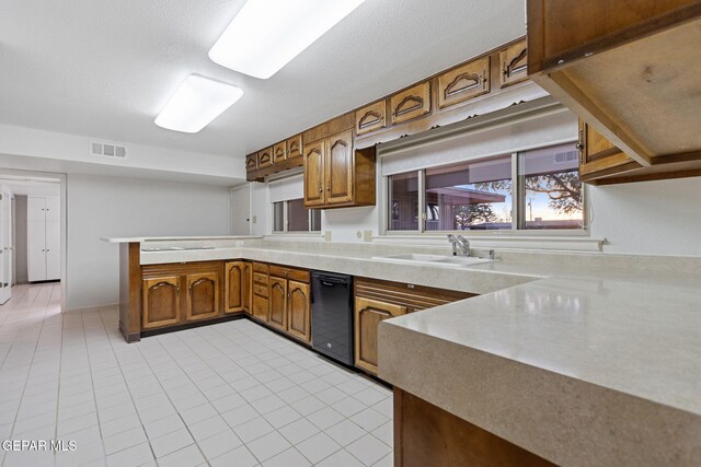 408 Spring Hill Cir, El Paso, TX 79912 - kitchen with a peninsula, brown cabinetry, light countertops, and light tile patterned floors