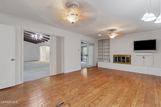 408 Spring Hill Cir, El Paso, TX 79912 - unfurnished living room featuring ceiling fan, light wood finished floors, a chandelier, a brick fireplace, and crown molding