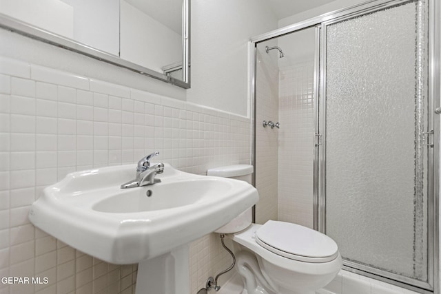 408 Spring Hill Cir, El Paso, TX 79912 - full bathroom featuring tile walls, a shower stall, and a wainscoted wall