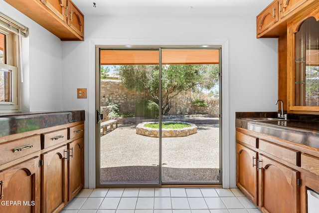 408 Spring Hill Cir, El Paso, TX 79912 - kitchen with dark countertops, brown cabinets, and light tile patterned floors