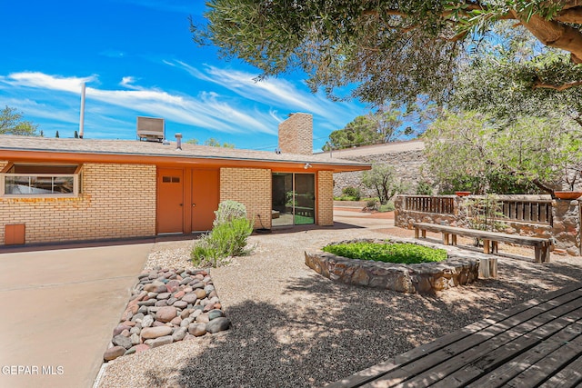 408 Spring Hill Cir, El Paso, TX 79912 - view of front facade featuring a chimney, brick siding, and a patio area