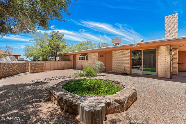 408 Spring Hill Cir, El Paso, TX 79912 - back of house with brick siding, a patio area, a chimney, and driveway