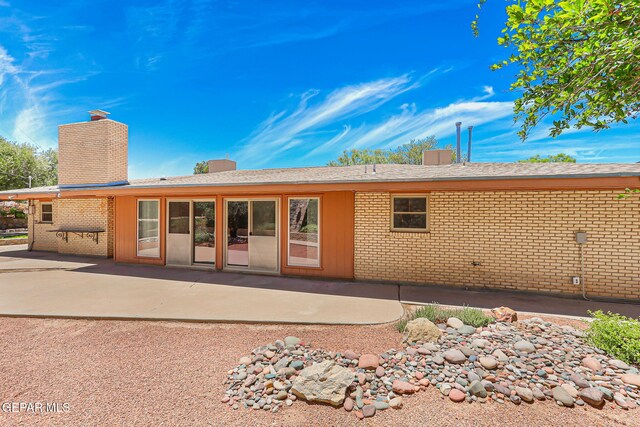 408 Spring Hill Cir, El Paso, TX 79912 - rear view of house with a chimney, brick siding, and a patio area