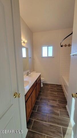 3541 Al Roberts Dr, El Paso, TX 79936 - bathroom featuring double vanity, toilet, shower / bathtub combination, and wood finished floors