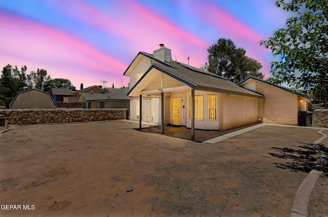 11364 Crater Lake Ave, El Paso, TX 79936 - back of house with a chimney, a patio, brick siding, and solar panels
