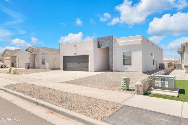 14423 Kayla Mia Dr, El Paso, TX 79938 - view of front facade with concrete driveway, an attached garage, stucco siding, and central AC unit