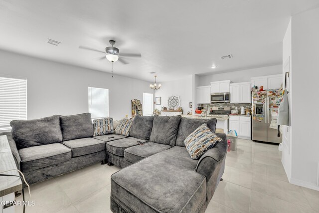 14423 Kayla Mia Dr, El Paso, TX 79938 - living area featuring ceiling fan, a chandelier, light tile patterned floors, and baseboards