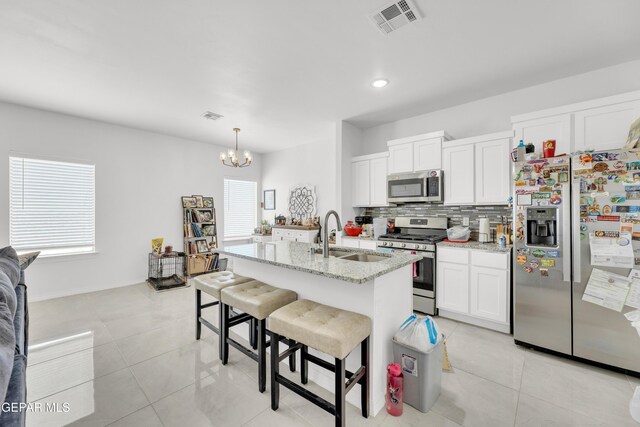 14423 Kayla Mia Dr, El Paso, TX 79938 - kitchen featuring appliances with stainless steel finishes, a sink, backsplash, a chandelier, and a kitchen breakfast bar