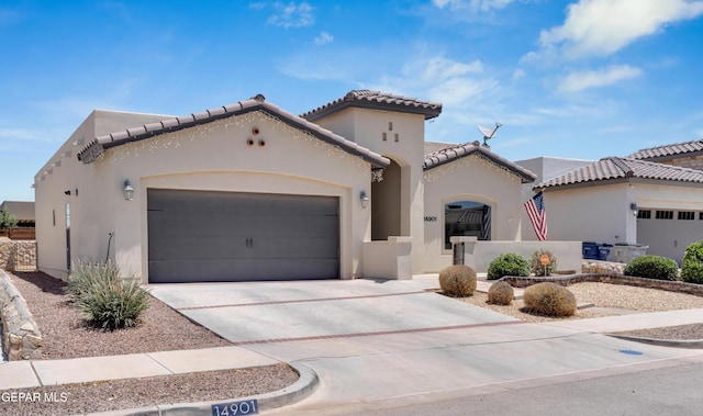 14901 Ted Banks Ave, El Paso, TX 79938 - mediterranean / spanish house featuring an attached garage, stucco siding, driveway, and a tile roof