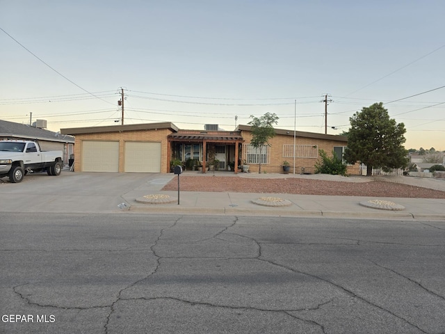 7000 Armistad Ave, El Paso, TX 79912 - view of front of home featuring an attached garage, concrete driveway, and brick siding