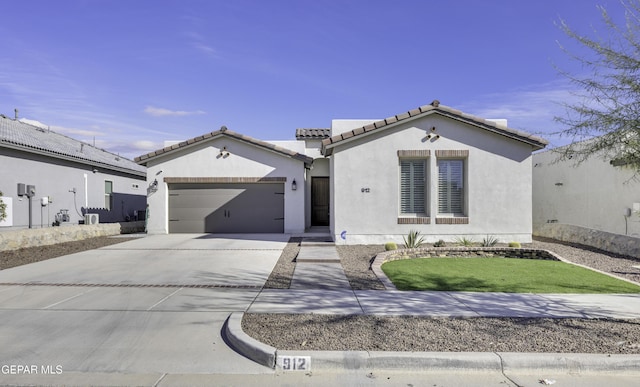 912 Malven Pl, El Paso, TX 79928 - mediterranean / spanish home with concrete driveway, a tile roof, a garage, and stucco siding