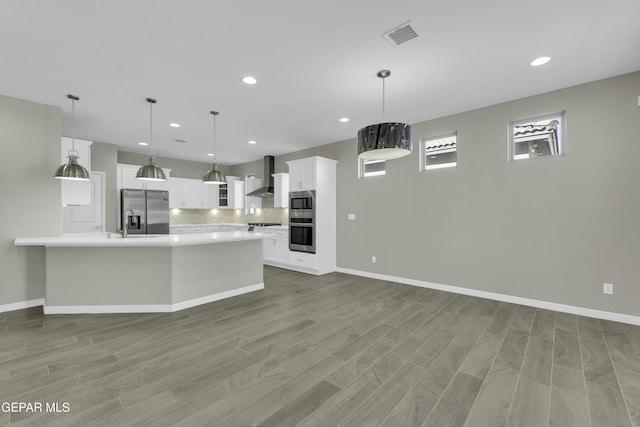 912 Malven Pl, El Paso, TX 79928 - kitchen featuring appliances with stainless steel finishes, wall chimney range hood, decorative backsplash, light countertops, and white cabinets
