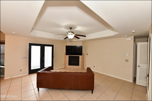 12712 Tierra Aurora Dr, El Paso, TX 79938 - unfurnished living room featuring a tray ceiling, light tile patterned flooring, and a ceiling fan