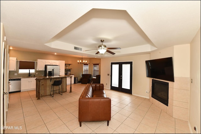 12712 Tierra Aurora Dr, El Paso, TX 79938 - living room with a raised ceiling, light tile patterned floors, ceiling fan, and plenty of natural light