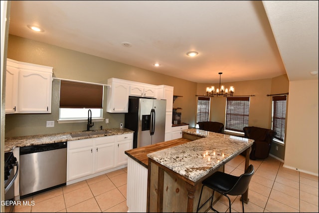 12712 Tierra Aurora Dr, El Paso, TX 79938 - kitchen with stainless steel appliances, light tile patterned floors, white cabinets, a chandelier, and recessed lighting