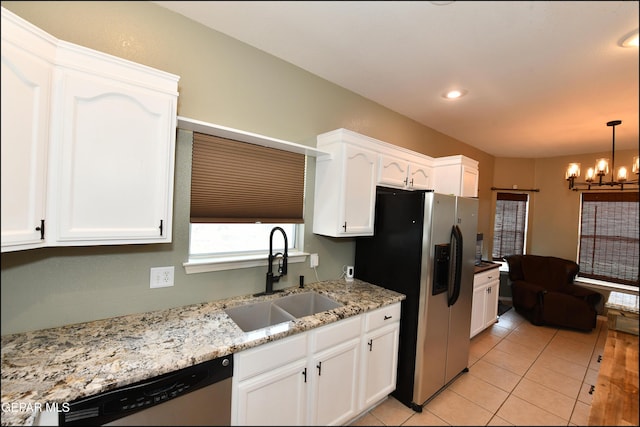 12712 Tierra Aurora Dr, El Paso, TX 79938 - kitchen featuring appliances with stainless steel finishes, a chandelier, white cabinetry, light tile patterned floors, and decorative light fixtures