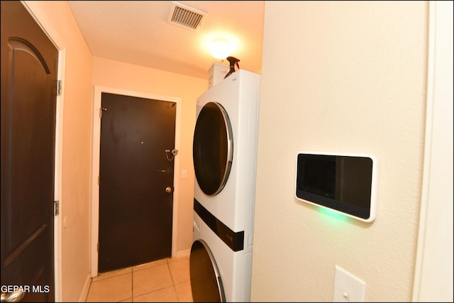 12712 Tierra Aurora Dr, El Paso, TX 79938 - washroom featuring stacked washing machine and dryer and light tile patterned floors