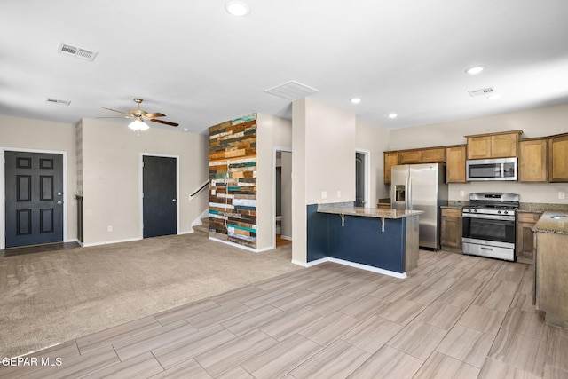 11470 Dawn View Rd Unit B, Socorro, TX 79927 - kitchen featuring appliances with stainless steel finishes, open floor plan, brown cabinets, a ceiling fan, and recessed lighting