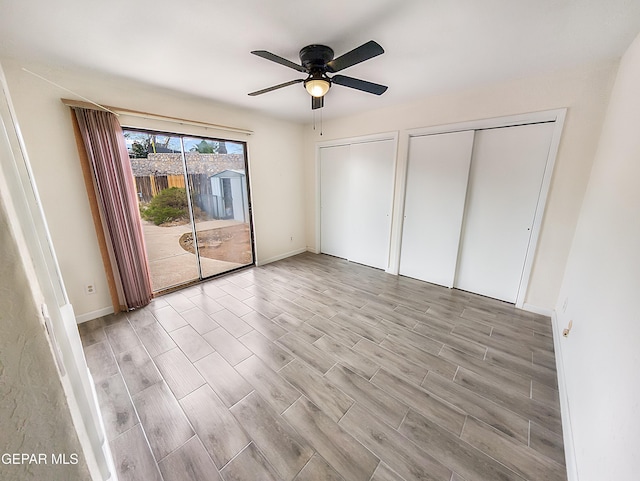 3425 Dialrock Ln, El Paso, TX 79935 - unfurnished bedroom featuring access to exterior, two closets, light wood-style floors, and ceiling fan