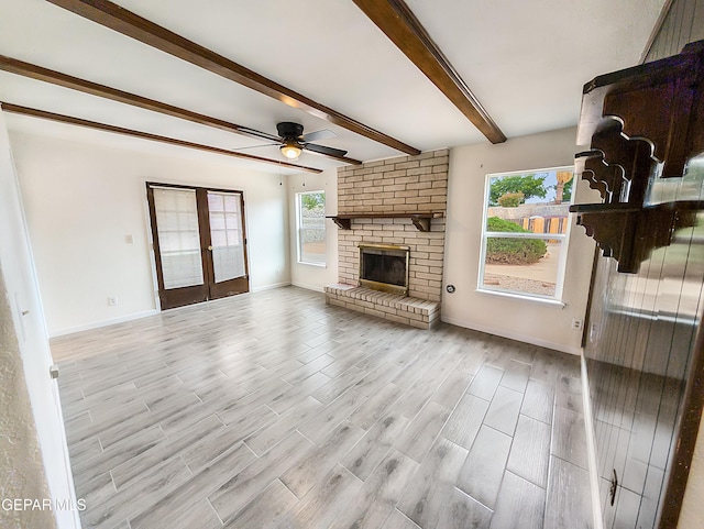 3425 Dialrock Ln, El Paso, TX 79935 - unfurnished living room featuring beamed ceiling, ceiling fan, a brick fireplace, light wood-style floors, and french doors