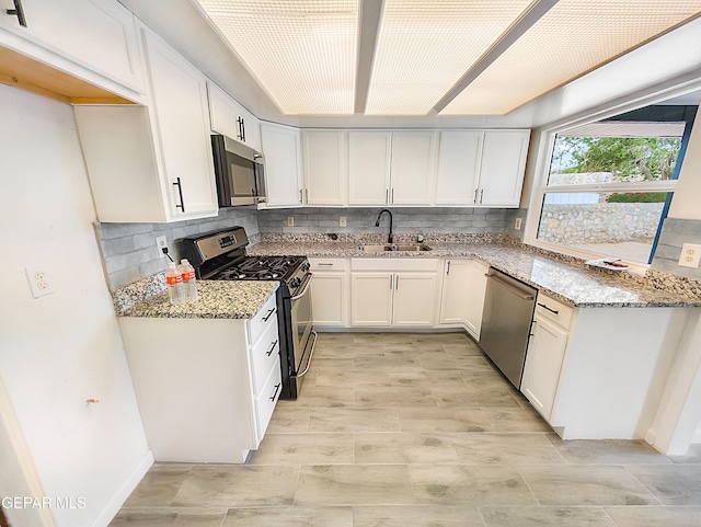 3425 Dialrock Ln, El Paso, TX 79935 - kitchen with appliances with stainless steel finishes, light stone countertops, white cabinetry, and decorative backsplash