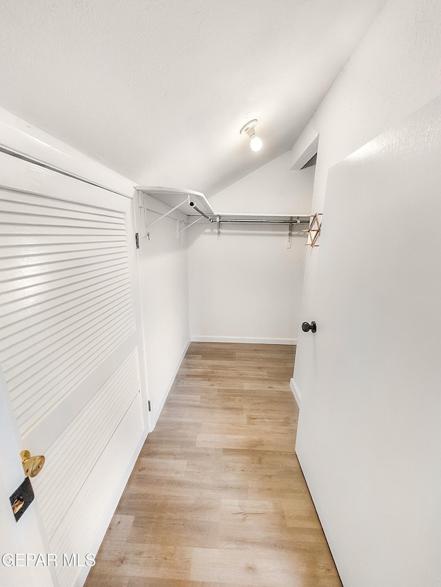 3425 Dialrock Ln, El Paso, TX 79935 - walk in closet featuring light wood-style flooring and lofted ceiling