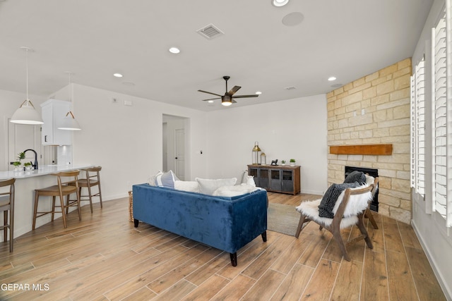 905 Bilton Pl, El Paso, TX 79928 - living room with light wood-style flooring, ceiling fan, recessed lighting, and a stone fireplace