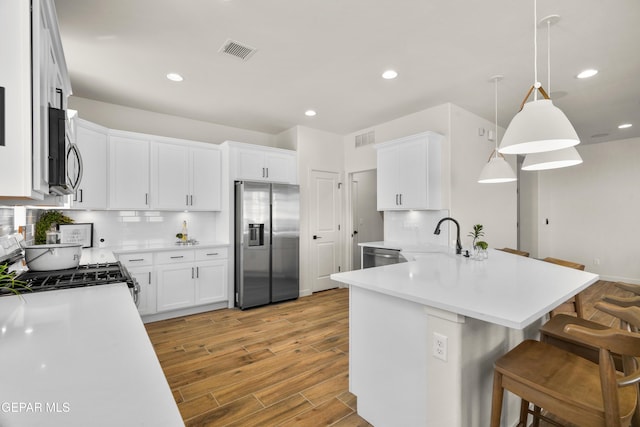 905 Bilton Pl, El Paso, TX 79928 - kitchen with stainless steel appliances, a kitchen bar, a peninsula, backsplash, and recessed lighting