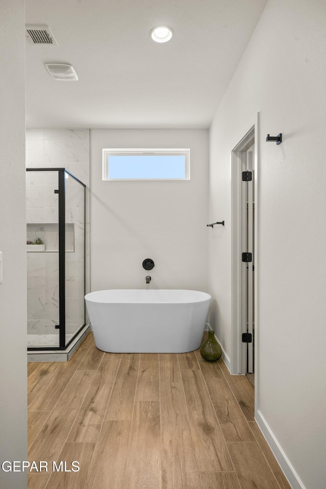 905 Bilton Pl, El Paso, TX 79928 - full bathroom featuring a freestanding tub, a shower stall, and wood finished floors