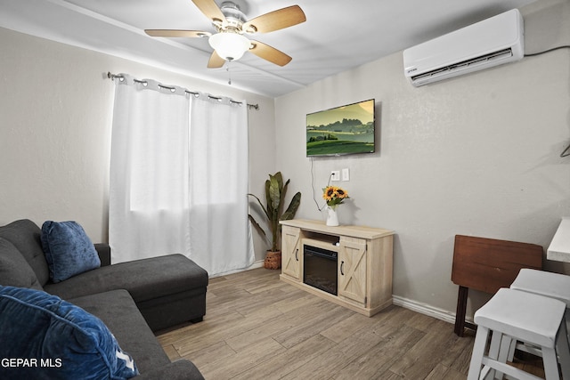3031 Memphis Ave, El Paso, TX 79930 - living area with a wall mounted air conditioner, light wood-style floors, a ceiling fan, and a glass covered fireplace