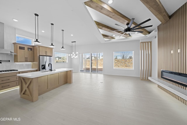 3932 Surmise St, El Paso, TX 79938 - kitchen featuring open floor plan, stainless steel fridge with ice dispenser, a ceiling fan, light countertops, and wall chimney range hood