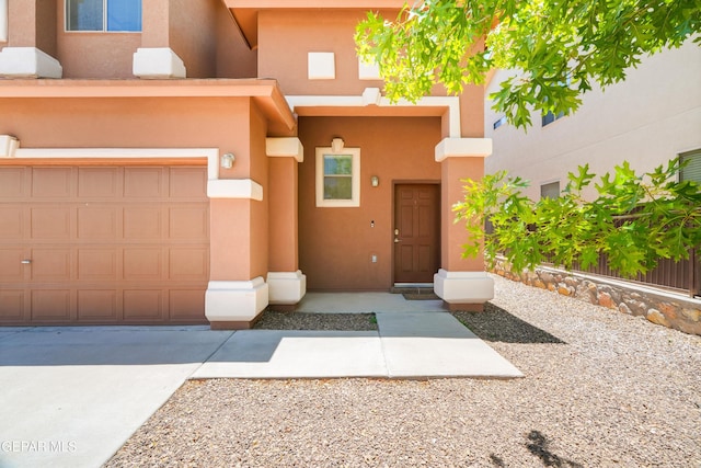 5036 Silver Ranch Ave, El Paso, TX 79934 - doorway to property featuring a garage, stucco siding, and driveway