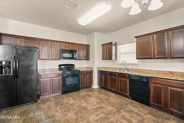 5036 Silver Ranch Ave, El Paso, TX 79934 - kitchen featuring black appliances, a chandelier, dark brown cabinets, and stone finish floors