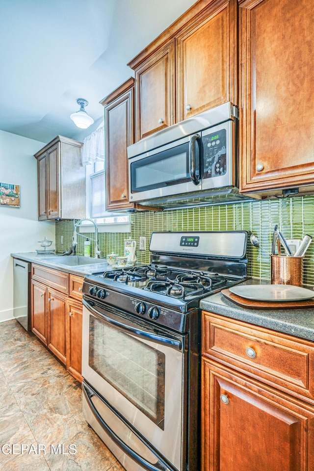 4021 Hastings Dr, El Paso, TX 79903 - kitchen with stainless steel appliances, decorative backsplash, brown cabinets, and light stone finish floors