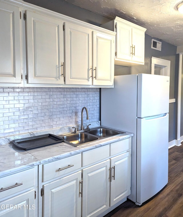3308 Tularosa Ave, El Paso, TX 79903 - kitchen with white cabinets, backsplash, dark wood-style flooring, and a textured ceiling