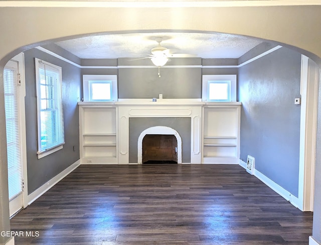 3308 Tularosa Ave, El Paso, TX 79903 - unfurnished living room with ceiling fan, healthy amount of natural light, dark wood-type flooring, a fireplace, and a textured ceiling