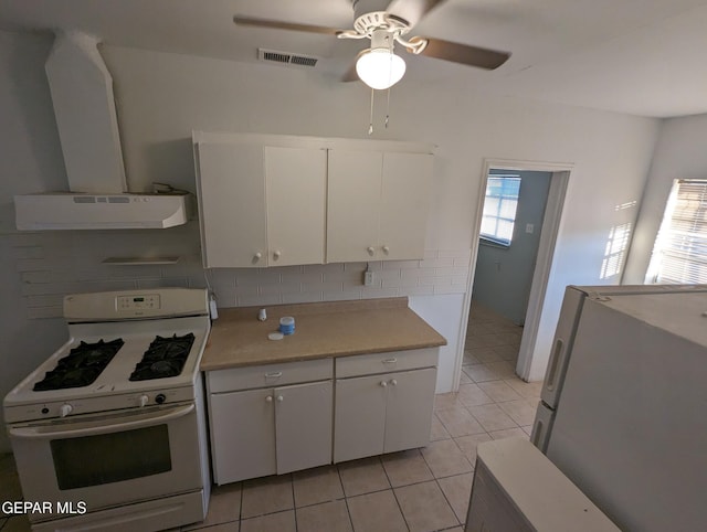 3308 Tularosa Ave, El Paso, TX 79903 - kitchen with white appliances, exhaust hood, light countertops, light tile patterned floors, and white cabinetry