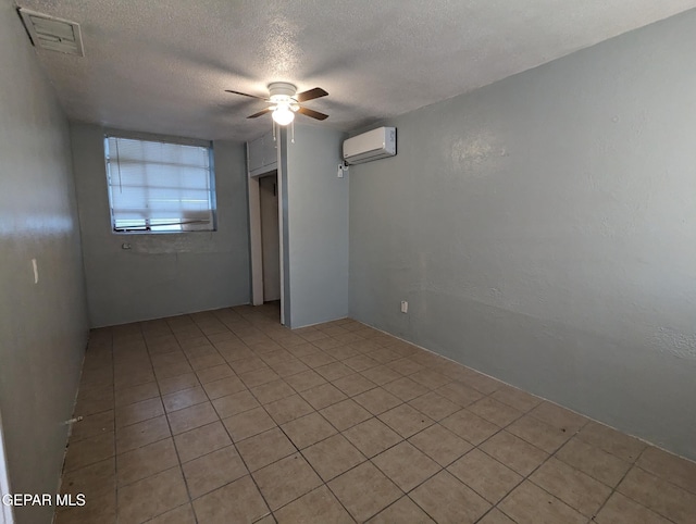 3308 Tularosa Ave, El Paso, TX 79903 - unfurnished room with an AC wall unit, a textured ceiling, ceiling fan, and light tile patterned floors